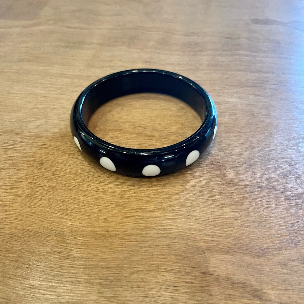 Black bracelet with white dots.